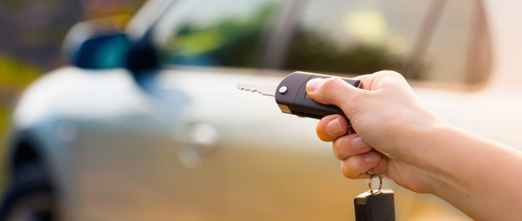 Person holding key to unlock a car